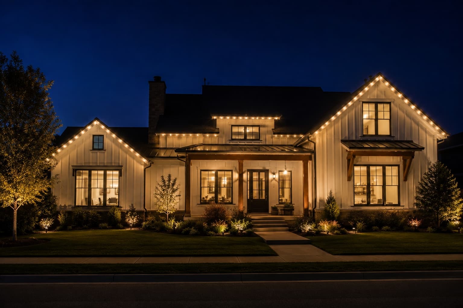 Home with permanent eave lighting glowing warm white at night; the track is invisible during the day